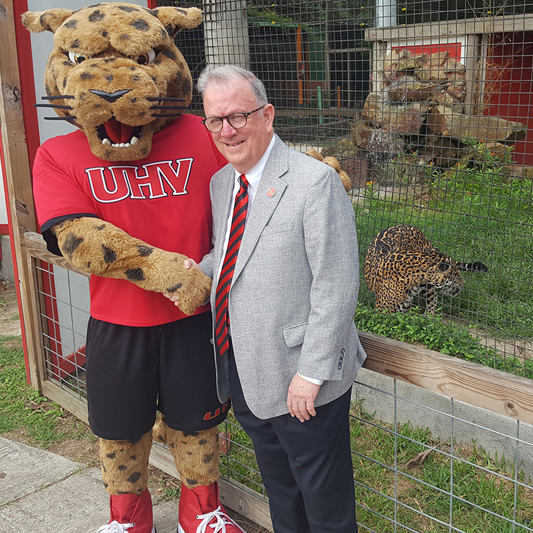 UHV president and jaX mascot posing with jaX jaguar at the Texas Zoo
